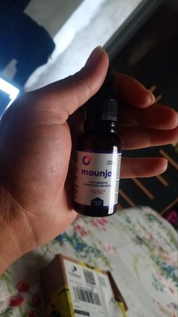 Avaliador segurando o frasco do suplemento Mounjax, destacando a tampa conta-gotas que facilita a aplicação sublingual.